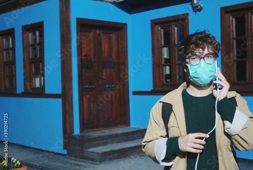 Travelling person in mask holding phone 
