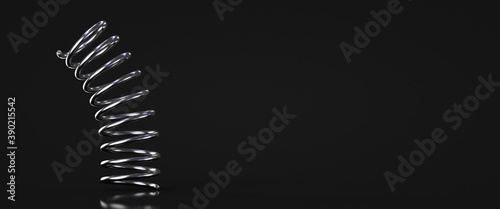 The metal spring bounces off the floor. Dark background. Copy space. photo