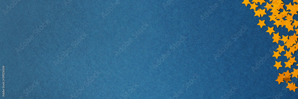 Blue background with golden stars. New year texture. Copy space. Extra wide Blue background with golden stars. New year texture. Copy space. Extra wide