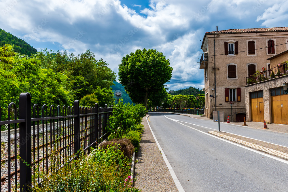 An empty rural road and old buildings in a French medieval village Puget-Theniers in the low Alps on a sunny day (Alpes-Maritimes, France)