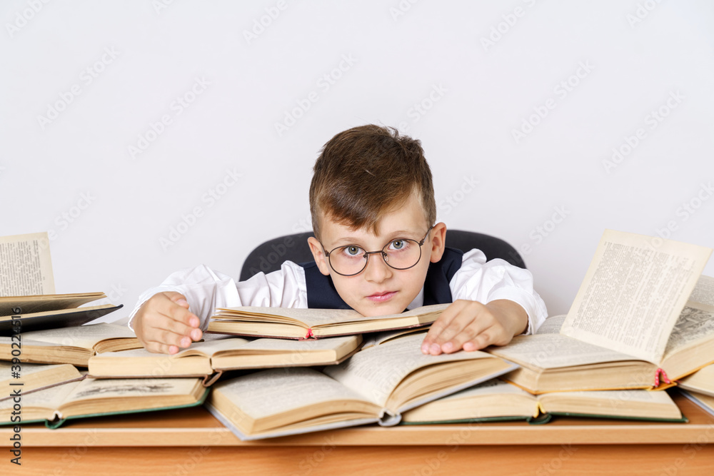 The student lay down on open books, looks at the camera. Isolated on white background. The student lay down on open books, looks at the camera. Isolated on white background.
