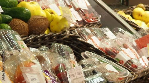 fruits and dried fruits in the store, in packaging, a woman chooses Supermarket , fruit and vegetable zone. photo