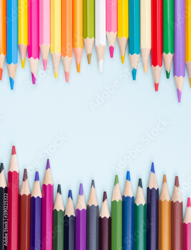 Color pencils on blue background top view with space for text or creativity.Close up.