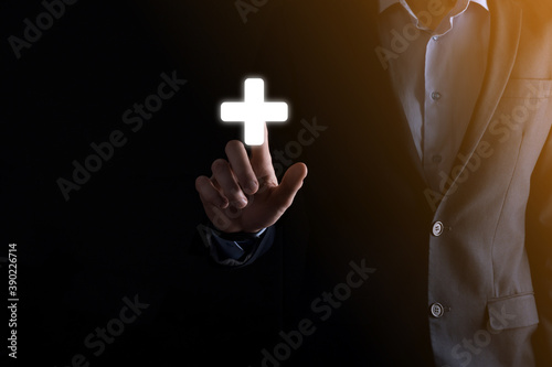 Businessman in a suit with an outstretched finger on his hand clicks on the plus icon
