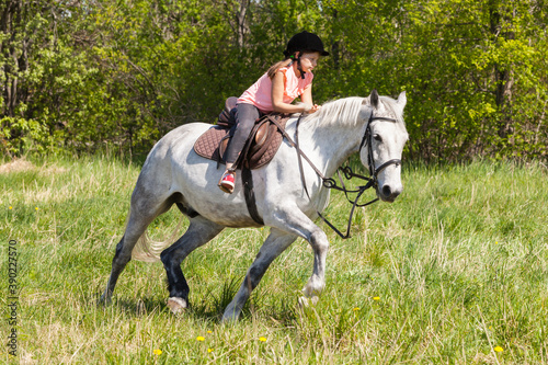 Cute little girl rides white horse © evannovostro
