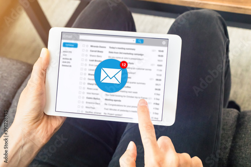 Email inbox notification with woman receiving new incoming message at home on digital tablet computer, e-mail communication marketing concept photo