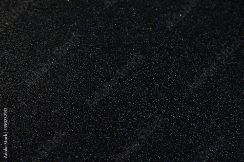 Black glitter texture Christmas abstract background, shiny vintage lights background. light silver and black, defocused. 