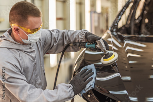 Wallpaper Mural An employee of the car body paint shop with a medical mask on his face polishes the painted surface Torontodigital.ca