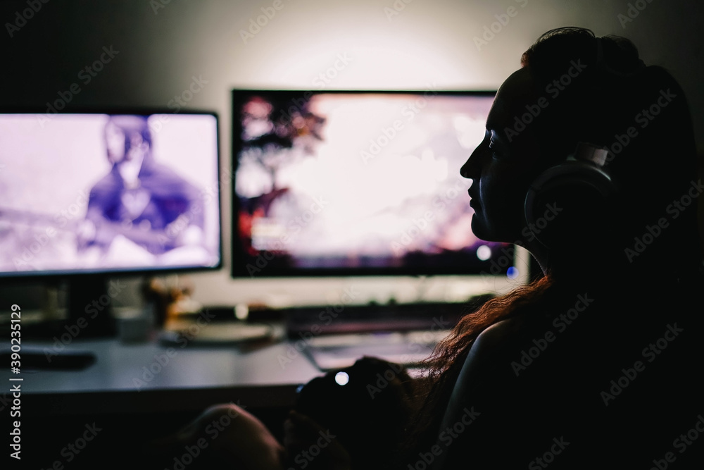 Gamer girl sitting at the monitor at night Gamer girl sitting at the monitor at night