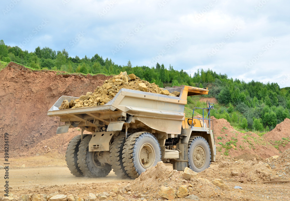 Mining truck and excavators working in the limestone open-pit. Loading and transportation of minerals in the dolomite mining quarry Mining truck and excavators working in the limestone open-pit. Loading and transportation of minerals in the dolomite mining quarry