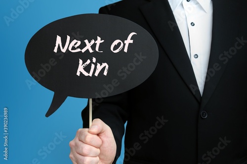 Next of Kin. Businessman holds speech bubble in his hand. Handwritten Word/Text on sign.