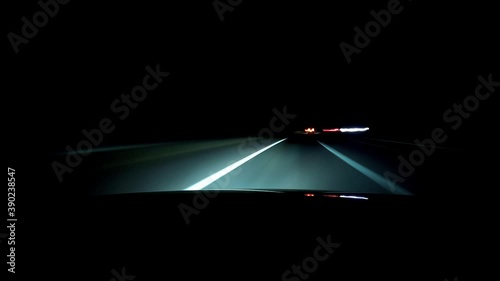 Timelapse video view from the hood of a car travelling fast at night. Fast motion and futuristic light trails to simulate speed. 4k