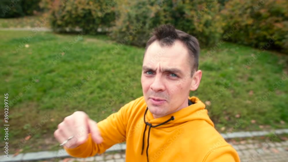 A male blogger makes a video release in the park. Emotionally talks, gestures, says information. Walk on the sidewalk. A male blogger makes a video release in the park. Emotionally talks, gestures, says information. Walk on the sidewalk.