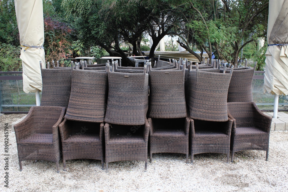 Obraz premium Greece, Athens, November 3 2020 - Chairs, tables and other furniture stacked outside closed cafe-restaurant, after the announcement for Covid-19 lockdown.