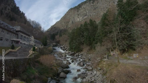 Pont d'Espagne / Cauterets / France - March 12, 2020: TILT SHOT - The Valley of Jeret with the river Marcadau in winter. The Griffons Thermal Establishment near Cauterets. photo