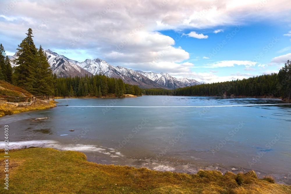 Scenic Landscape view of Frozen Johnson Lake with Ice Covered Surface near Banff in Canadian Rockies 