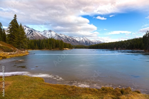 Scenic Landscape view of Frozen Johnson Lake with Ice Covered Surface near Banff in Canadian Rockies 