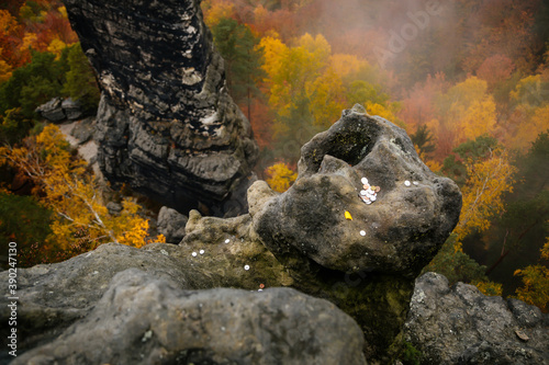 High sandstone cliff on autumn forest background, landscape near Pravcicka gate (Prebischtor) rock formation in Bohemian Switzerland national park, Czech Republic