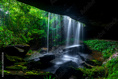 Fototapeta Naklejka Na Ścianę i Meble -  A small waterfall in the deep forest of the border of Thailand and Cambodia,ASIA.Khun Sri waterfall in tropical forest,Sisaket province,Thailand. Leaf moving low speed shutter blur.