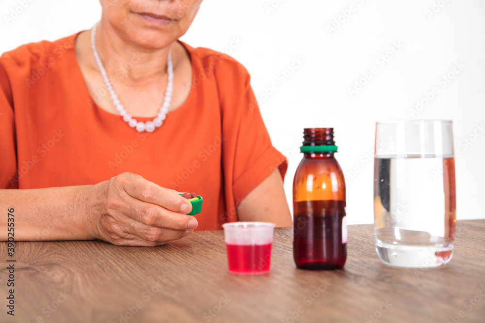 The old lady of the yellow race is about to take medicine to treat her illness The old lady of the yellow race is about to take medicine to treat her illness