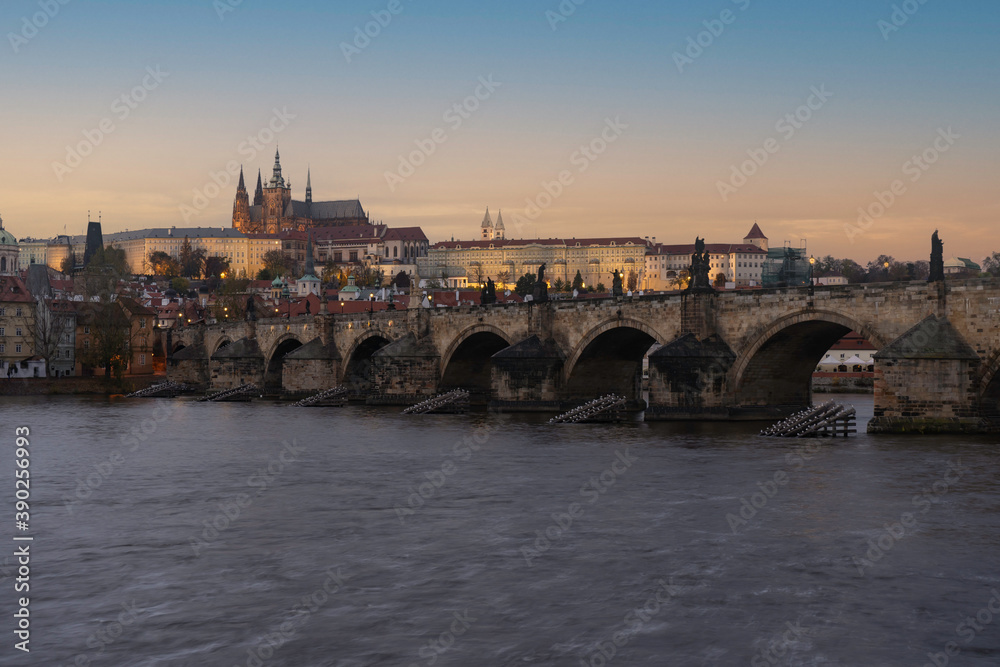 view of Prague Castle and the Cathedral of St. Vitus and Charles Bridge from the 14th century in the center of Prague at the sunset of the moon and the sky is colored