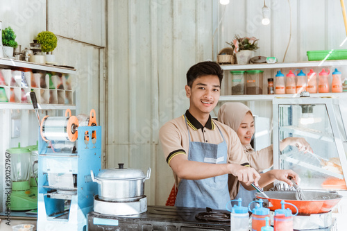 small business shop showing a muslim man and woman working in the kitchen photo