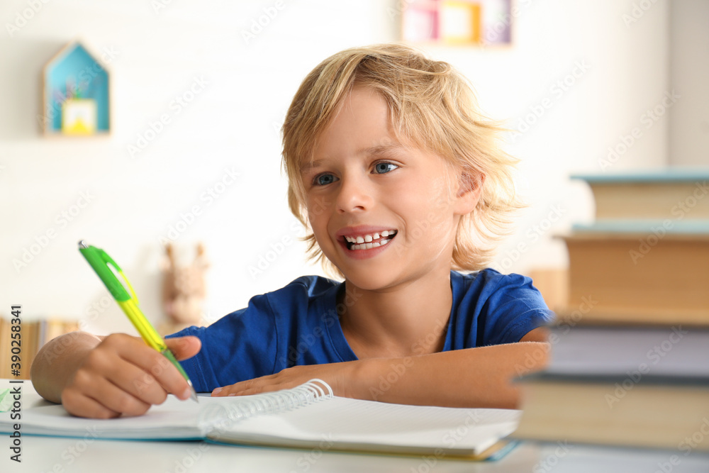 Little boy doing homework at table indoors Little boy doing homework at table indoors