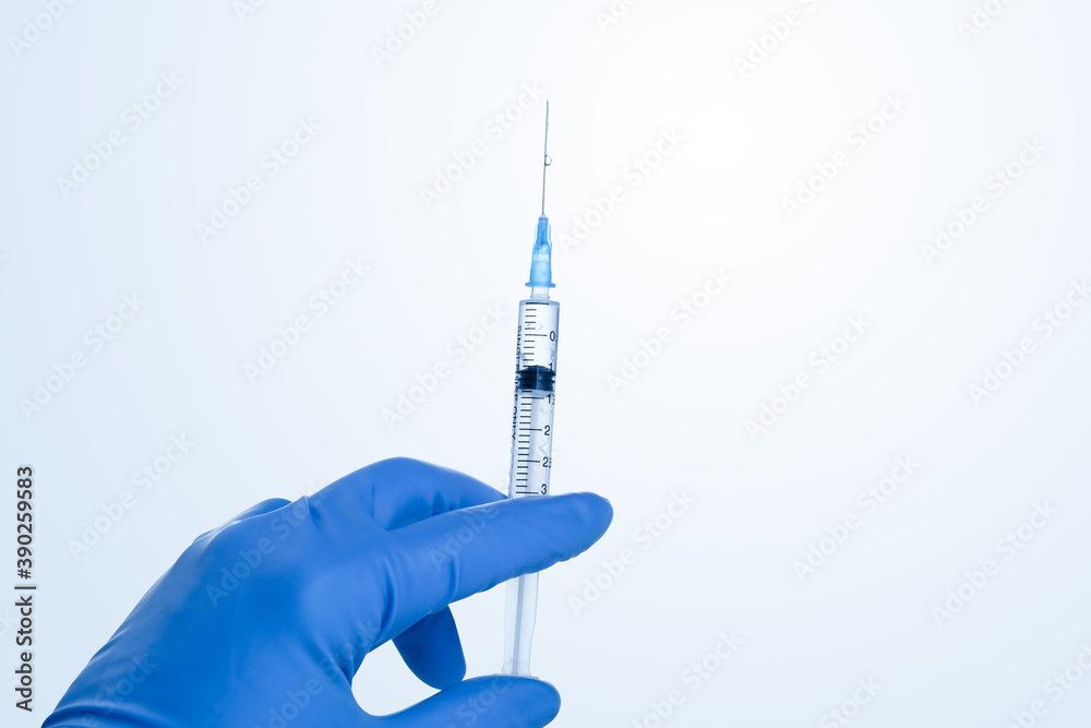 Hand holding syringe with vaccine against corona virus.