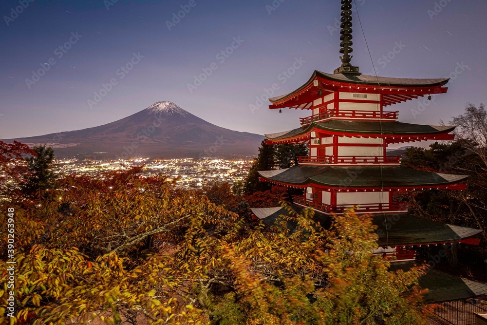 Night atmosphere at full moon at Chureito Pagoda and Mount Fuji with Fujiyoshida night lights in autumn