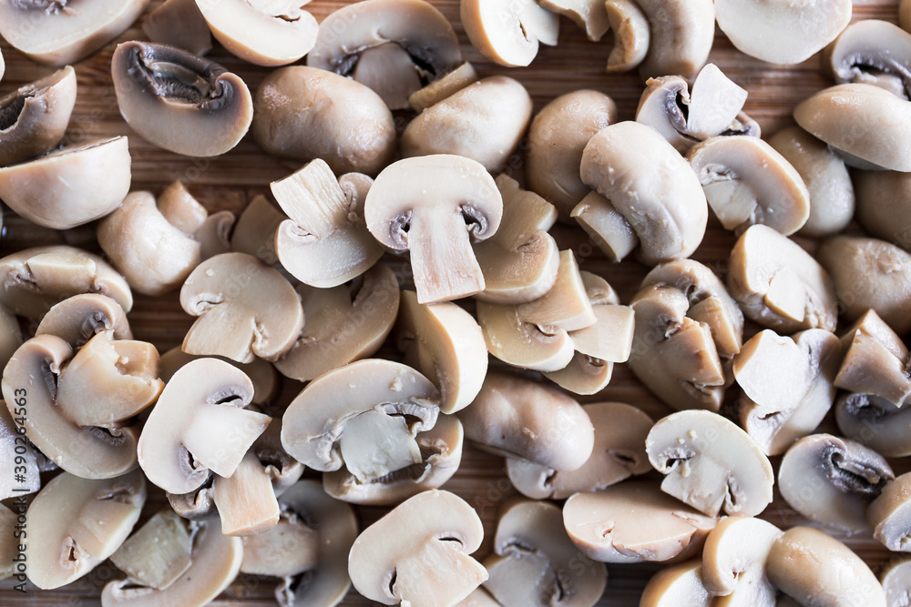 simple food ingredients, champignon mushrooms cut in halves on chopping board simple food ingredients, champignon mushrooms cut in halves on chopping board