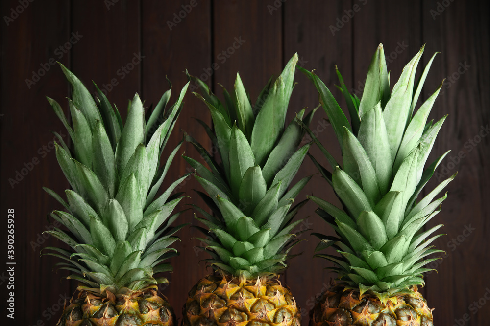 Fresh ripe juicy pineapples on wooden background Fresh ripe juicy pineapples on wooden background