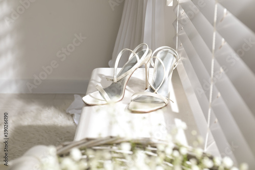 Beautiful wedding shoes on window sill indoors
