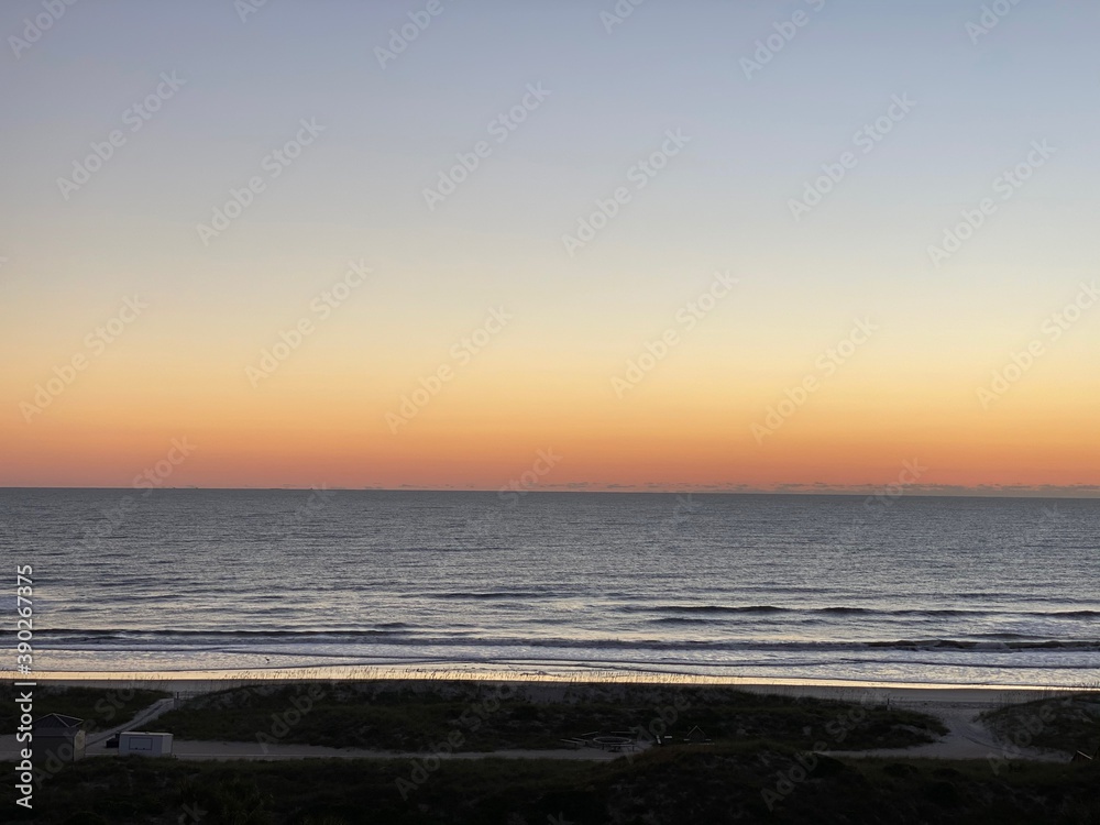 Sunset near beach coast with orange yellow sky landscape