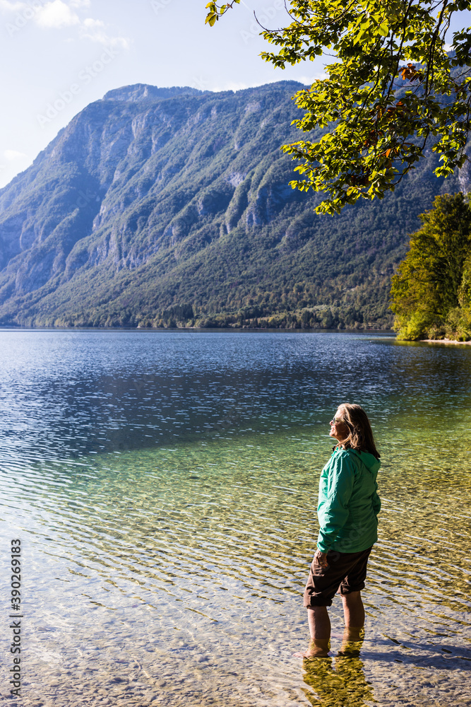 A young woman relaxing in a beautiful mountain lake in Slovenia, Europe.