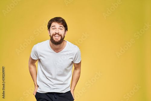 Man gesturing with hands emotions lifestyle white t-shirt yellow isolated background