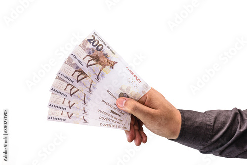 hand holding money, banknotes of two hundred reais from brazil, concept of thirteenth, salary bonus or fgts photo