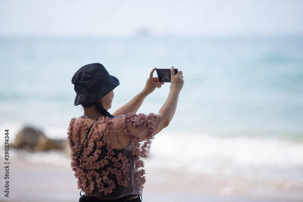 Asian woman in floral blouse taking selfies