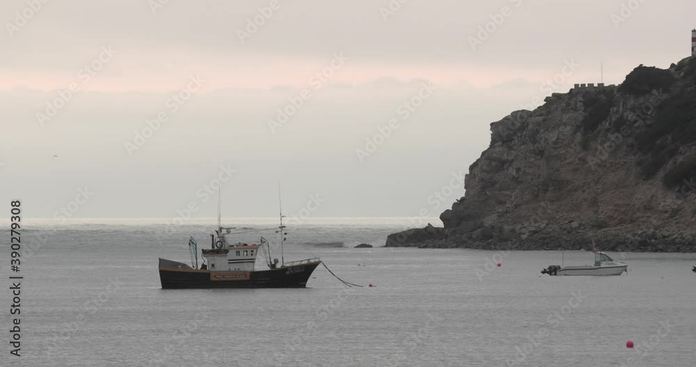 Solitary Boat Sailing By The Beach Of Sao Martinho Do Porto Caldas Da Rainha Portugal - wide shot Solitary Boat Sailing By The Beach Of Sao Martinho Do Porto Caldas Da Rainha Portugal - wide shot