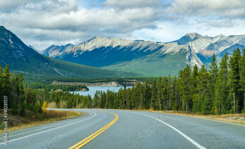 Rural road in the forest with mountains in the background. Alberta Highway 11 (David Thompson Hwy) along the Abraham lake shore. Jasper National Park, Canada. © Shawn.ccf