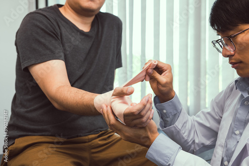 Fototapeta Naklejka Na Ścianę i Meble -  Asian physiotherapists are examining the results of wrist surgery of patients.