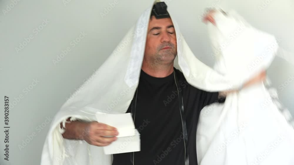 Jewish man praying with a tallit and tefillin Jewish man praying with a tallit and tefillin