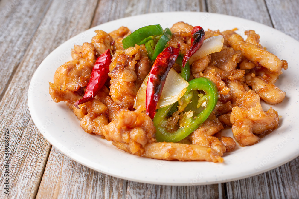 A view of a plate of hot and spicy chicken, in a restaurant or kitchen setting. A view of a plate of hot and spicy chicken, in a restaurant or kitchen setting.