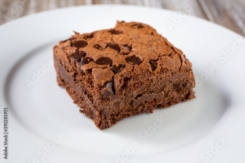 A closeup view of a chocolate chip brownie on a plate.