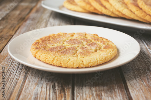 A view of a sugar cookie on a saucer, in a restaurant or kitchen setting.