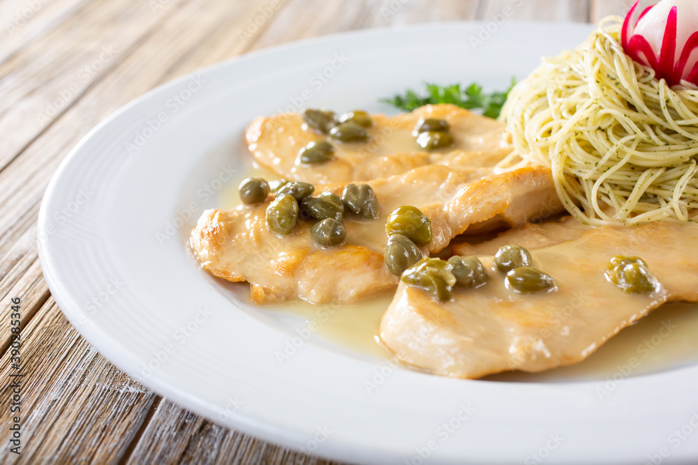 A view of a plate of chicken piccata. A view of a plate of chicken piccata.