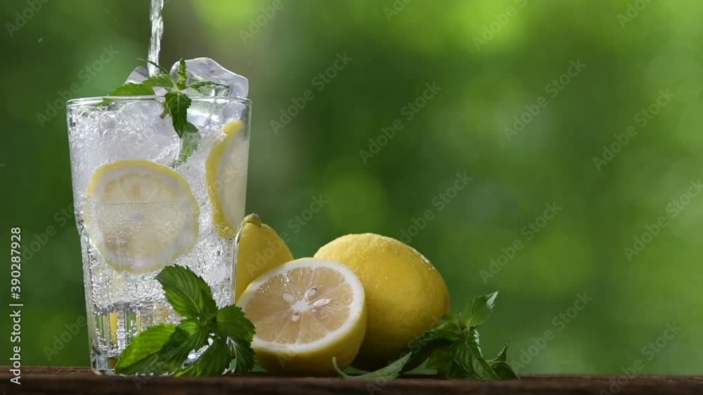 Fresh lemon juice pouring into glass	
