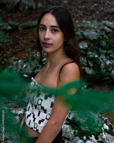 Vertical shot of a young beautiful Caucasian woman in the forest photo