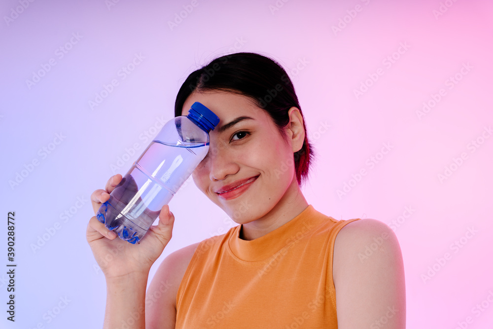 Young sport healthy asian woman with bottle of water isolate on pastel background. Young sport healthy asian woman with bottle of water isolate on pastel background.