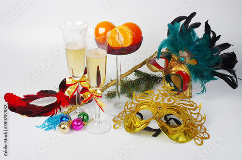 Carnival masks  two glasses of champagne  Christmas tree decorations on a white background.