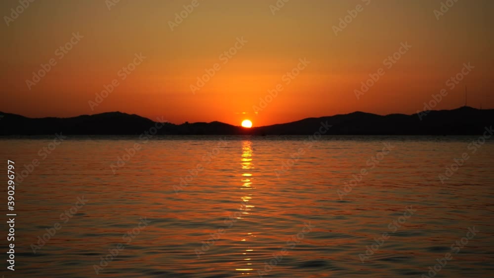 Beautiful orange sunset over the sea on the background of mountains. Beautiful orange sunset over the sea on the background of mountains.